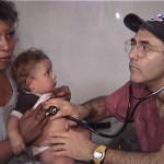 The doctor listens to a young patient's heart. medical missions trip